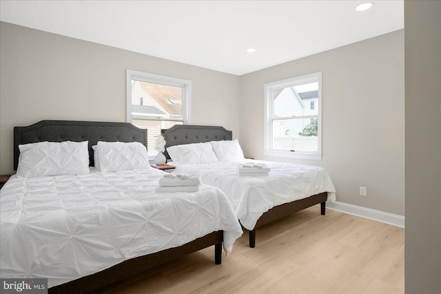 bedroom with multiple windows and light hardwood / wood-style floors