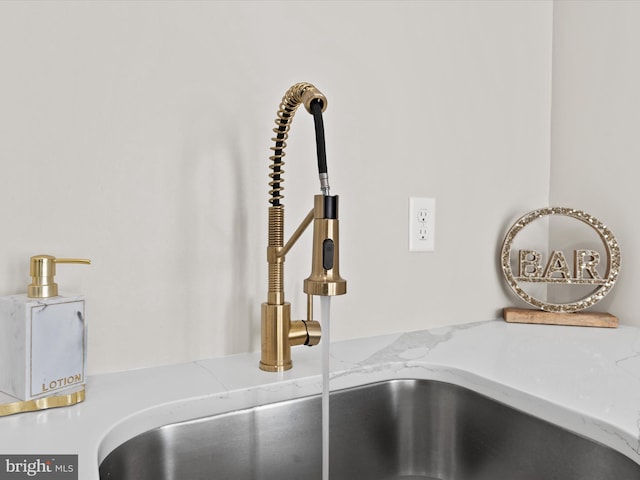 interior details with light stone countertops and sink