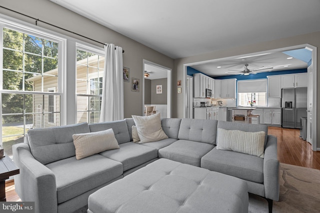 living room featuring hardwood / wood-style floors and ceiling fan