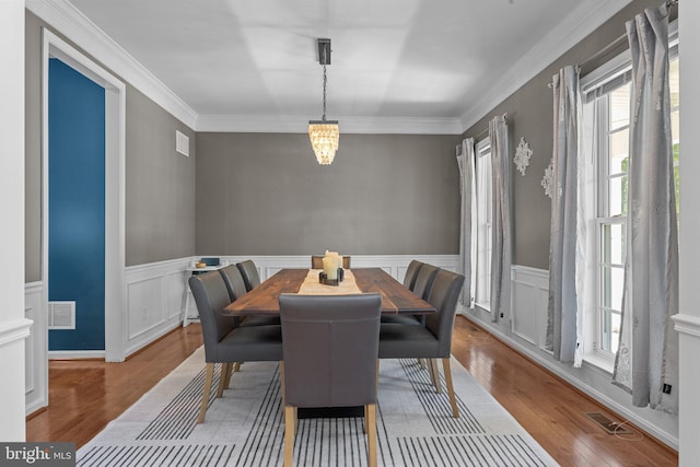 dining room with crown molding and hardwood / wood-style floors