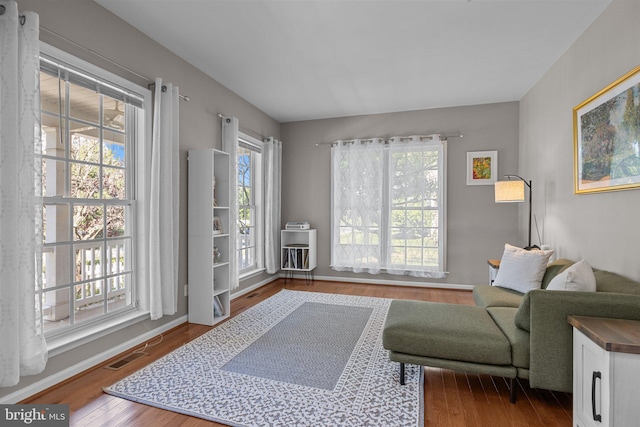 sitting room with wood-type flooring and a healthy amount of sunlight