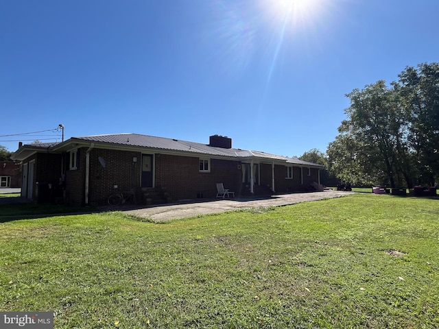 rear view of property featuring a patio area and a lawn