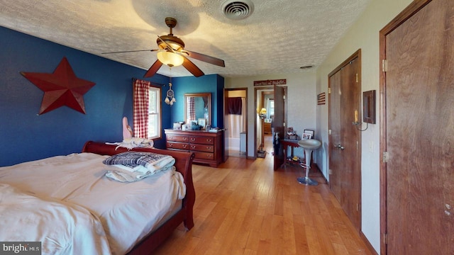 bedroom with ceiling fan, a textured ceiling, and light hardwood / wood-style flooring