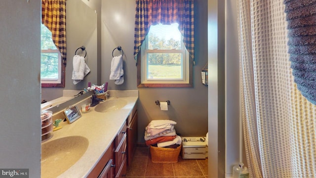 bathroom with double vanity, tile patterned flooring, and a sink