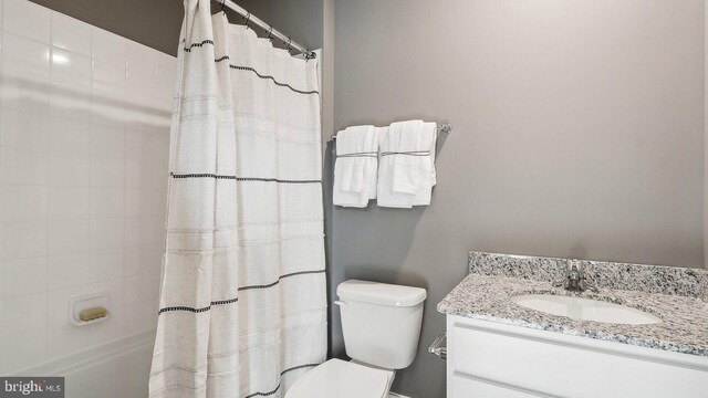 bathroom featuring vanity, curtained shower, and toilet