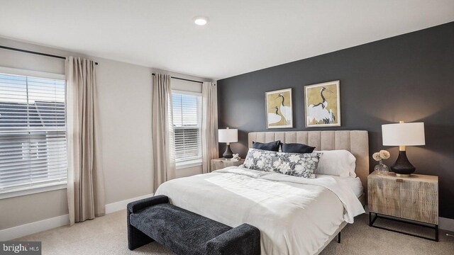 bedroom featuring light carpet and multiple windows