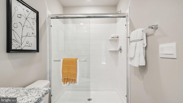 bathroom with toilet and an enclosed shower