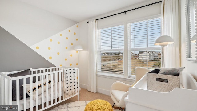 bedroom with a crib and light carpet