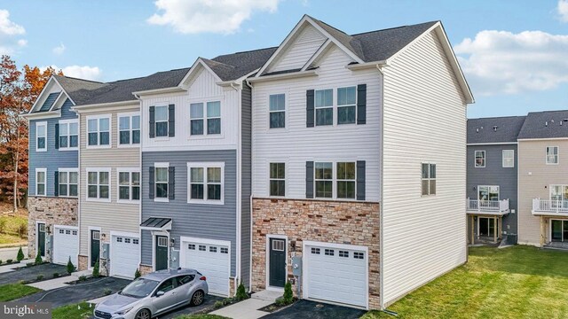 multi unit property featuring a front lawn and a garage