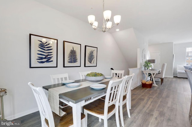 dining area featuring lofted ceiling, an inviting chandelier, and dark hardwood / wood-style flooring