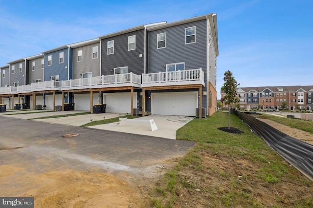 rear view of property featuring cooling unit and a garage