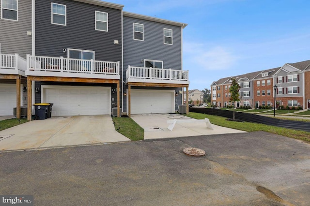 rear view of house featuring central AC unit and a garage