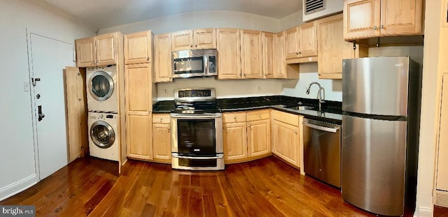 kitchen with light brown cabinetry, stainless steel appliances, sink, dark hardwood / wood-style floors, and stacked washer / drying machine