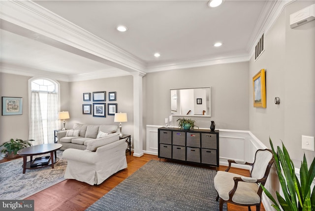 living room with wood finished floors, visible vents, ornate columns, recessed lighting, and crown molding