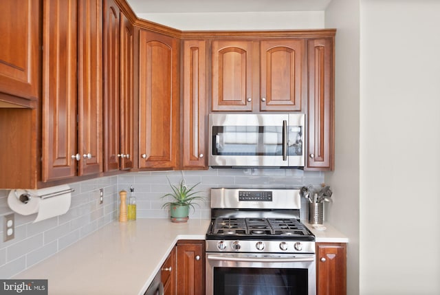 kitchen with decorative backsplash, light countertops, and stainless steel appliances