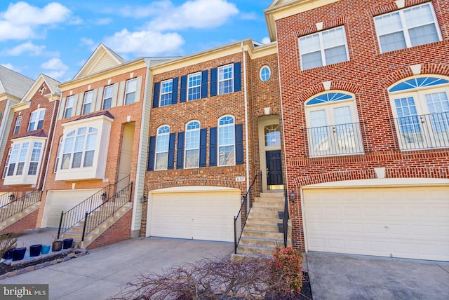 townhome / multi-family property featuring brick siding, concrete driveway, and an attached garage