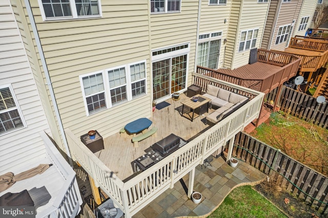 deck with an outdoor hangout area, a fenced backyard, and a patio area