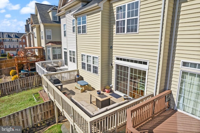 deck with area for grilling and a fenced backyard