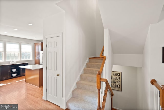 staircase with recessed lighting, baseboards, and wood finished floors