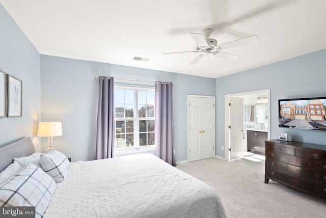 bedroom featuring visible vents, connected bathroom, carpet, baseboards, and ceiling fan