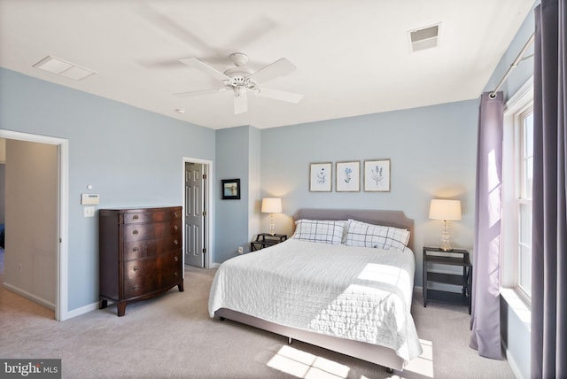 bedroom with visible vents, light carpet, and baseboards