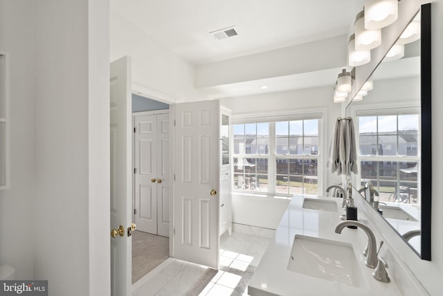 bathroom featuring double vanity, visible vents, marble finish floor, and a sink