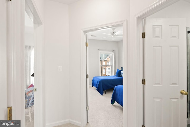 corridor featuring visible vents, baseboards, and carpet