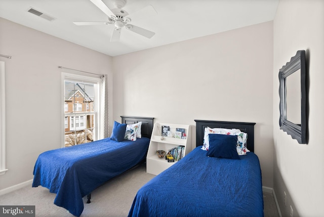 carpeted bedroom with visible vents, baseboards, and a ceiling fan