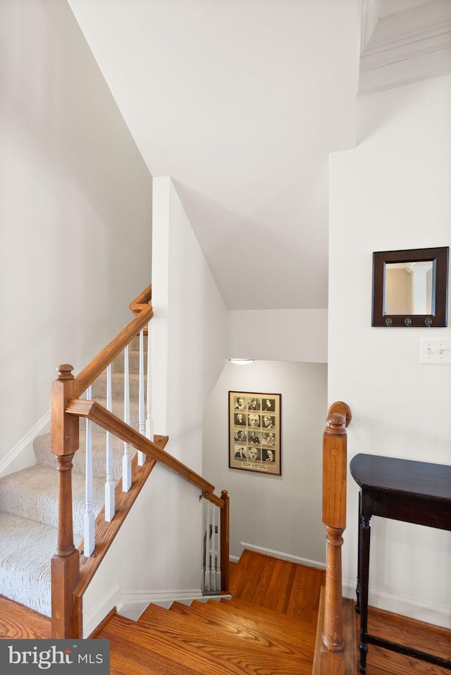 stairway with baseboards and wood finished floors