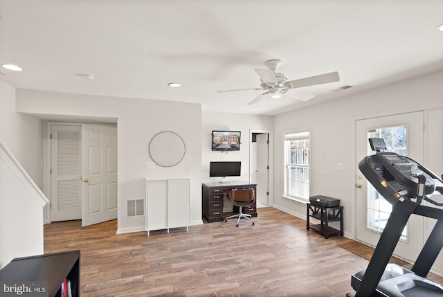 workout area featuring visible vents, ceiling fan, and wood finished floors