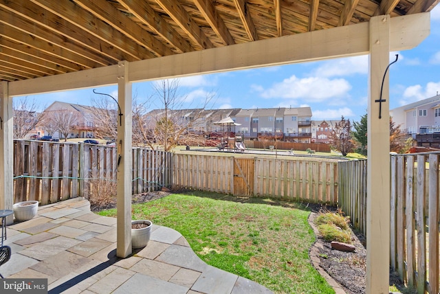 view of yard featuring a patio area, a residential view, and a fenced backyard