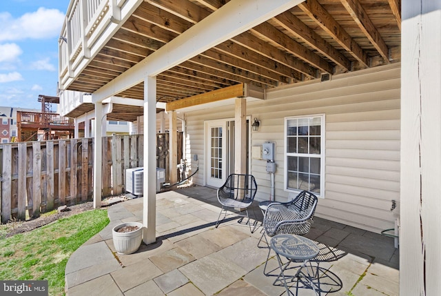 view of patio / terrace featuring central air condition unit and fence