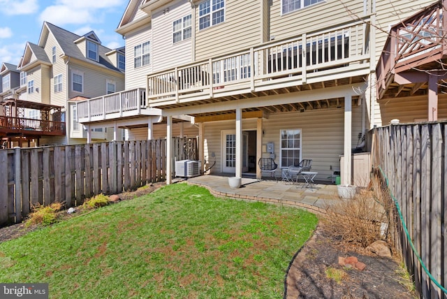 back of property with a patio, central AC unit, a fenced backyard, a lawn, and a residential view