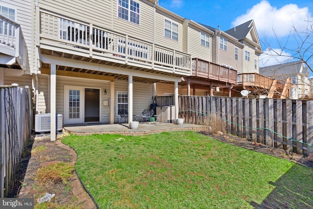 rear view of property featuring a patio, a lawn, central AC unit, and a fenced backyard