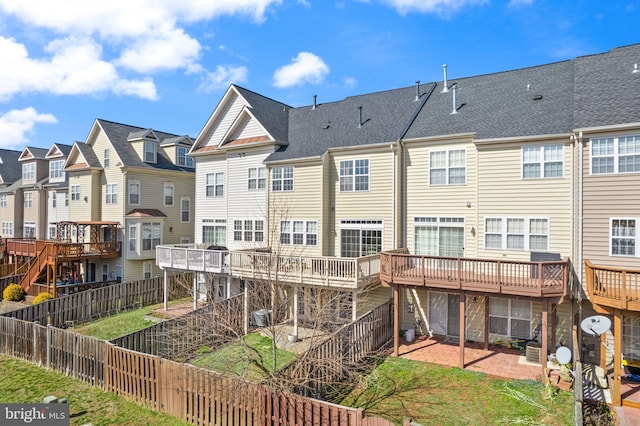 rear view of property featuring a residential view, a patio, a fenced backyard, and roof with shingles