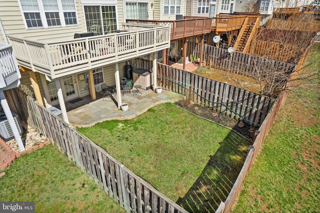 view of yard with a fenced backyard, a deck, and a patio