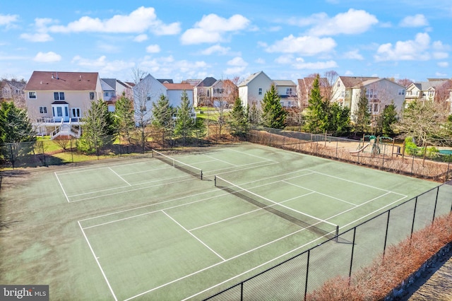 view of tennis court with a residential view, community basketball court, and fence