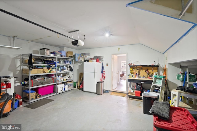 garage with a garage door opener and freestanding refrigerator