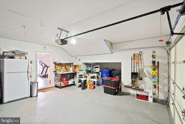 garage featuring a garage door opener and freestanding refrigerator