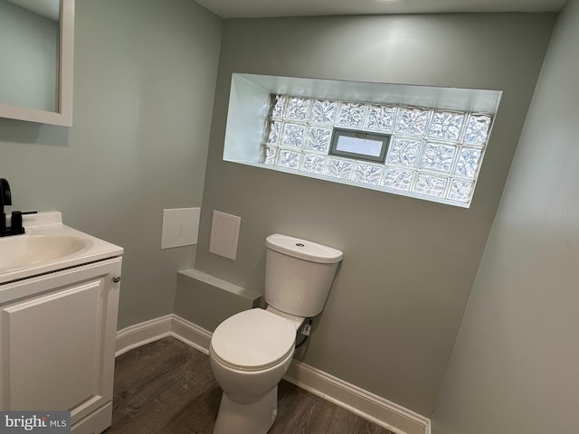 bathroom with vanity, toilet, and wood-type flooring