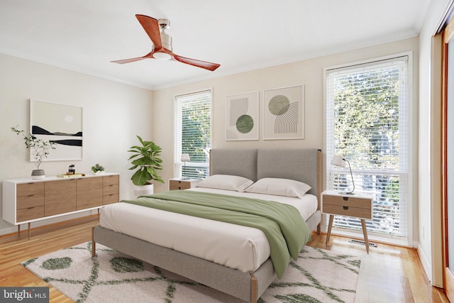 bedroom with ornamental molding, light hardwood / wood-style flooring, and ceiling fan