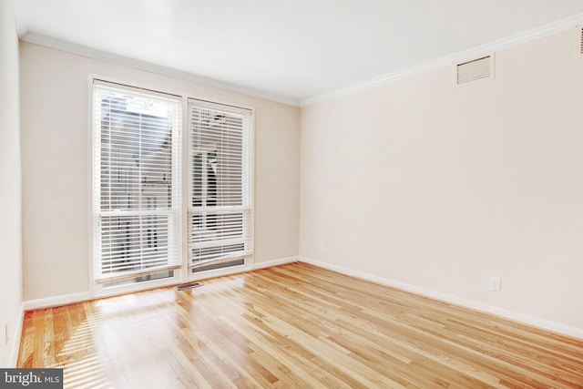 spare room featuring hardwood / wood-style flooring and ornamental molding