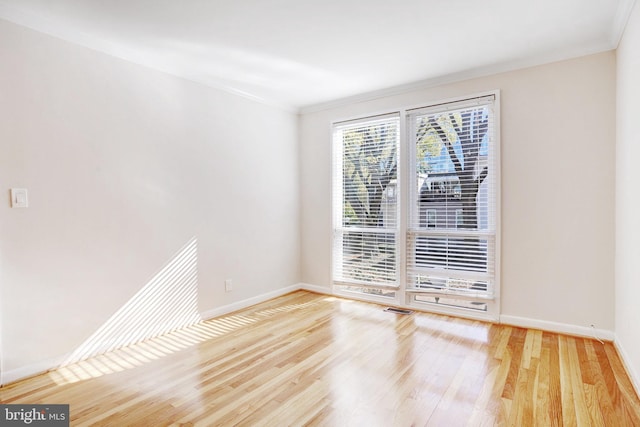 unfurnished room with ornamental molding and light hardwood / wood-style floors