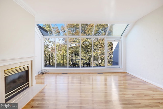 unfurnished living room with light hardwood / wood-style floors, a high end fireplace, plenty of natural light, and crown molding