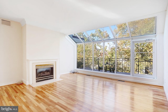 unfurnished living room featuring a skylight and light hardwood / wood-style flooring