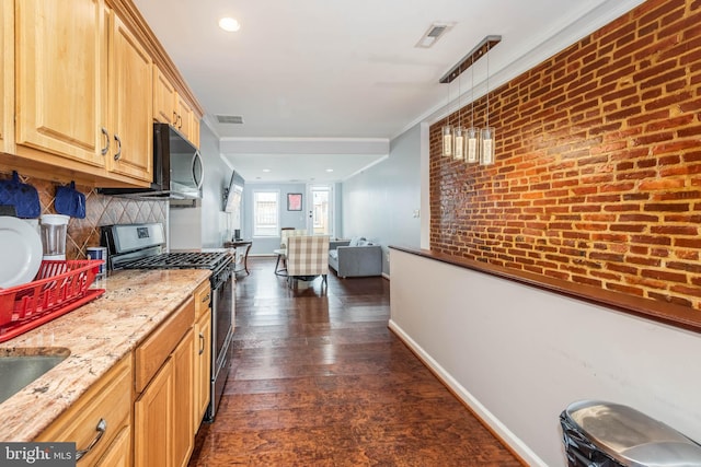 kitchen with gas stove, dark wood-type flooring, decorative light fixtures, ornamental molding, and brick wall