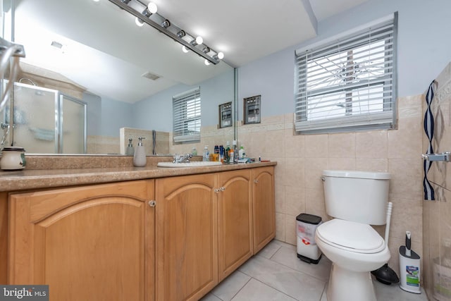 bathroom with vanity, tile walls, and toilet