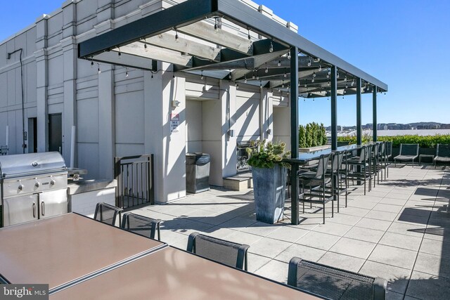 view of patio / terrace featuring area for grilling, a pergola, and an outdoor bar