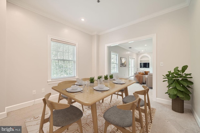 dining area featuring ornamental molding and light colored carpet