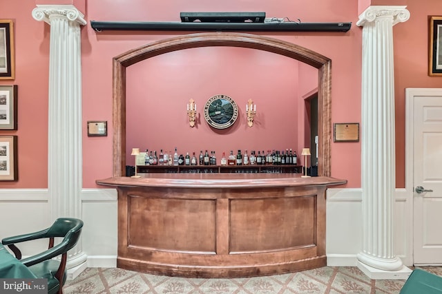 bar featuring tile patterned flooring and ornate columns